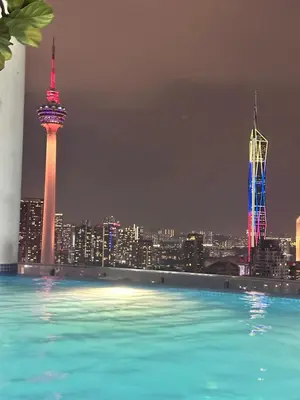 a pool with a view of a city at night at The Colony Infinitum KLCC Suits By Saidul in Kuala Lumpur