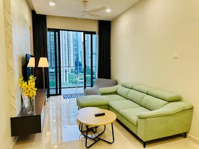a living room with a green couch and a table at KLCC City View luxury Suites in Kuala Lumpur
