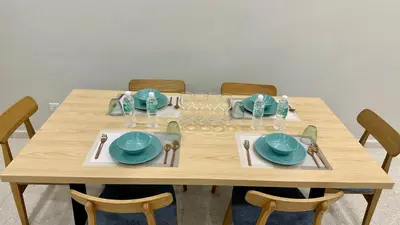 a wooden table with plates and dishes on it at KLCC City View luxury Suites in Kuala Lumpur