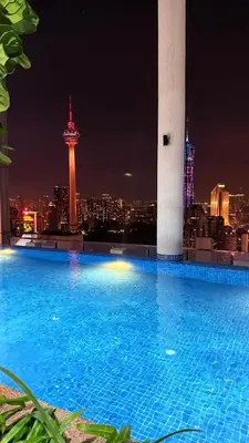 a large swimming pool with a city skyline at night at The Luxe Colony KLCC By KUALA LUMPUR in Kuala Lumpur