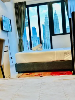 a bedroom with a bed with a view of a city at The Luxe Colony KLCC By KUALA LUMPUR in Kuala Lumpur