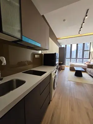 a kitchen with a sink and a living room at Sky Line Suites KL Podu in Kuala Lumpur