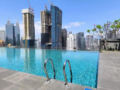 a swimming pool with a city skyline in the background at The Dorsett Bukit Bintang KL in Kuala Lumpur