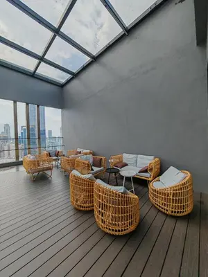a room with wicker chairs and tables and windows at Kuala Lumpur Services Apartments In A X O N Residence in Kuala Lumpur