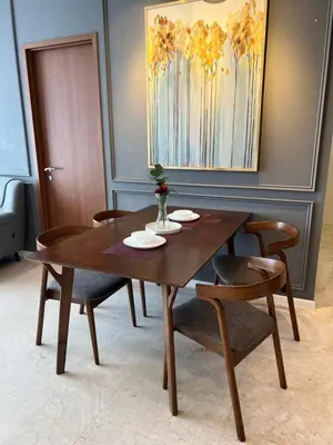 a dining room table with chairs and a wooden table at Sky suites klcc Family suites home in Kuala Lumpur