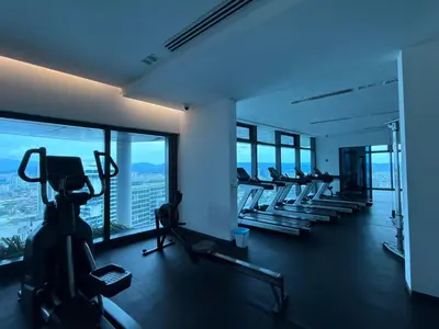 a gym with a row of tread machines in a building at IKON SUITE's E A T O N KLCC in Kuala Lumpur