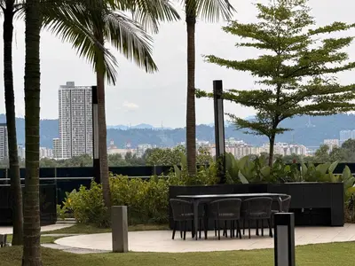 a table and chairs in a park with palm trees at IKON SUITE's E A T O N KLCC in Kuala Lumpur