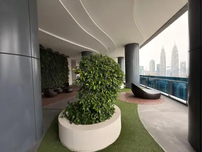 a building with a green plant on a balcony at IKON SUITE's E A T O N KLCC in Kuala Lumpur