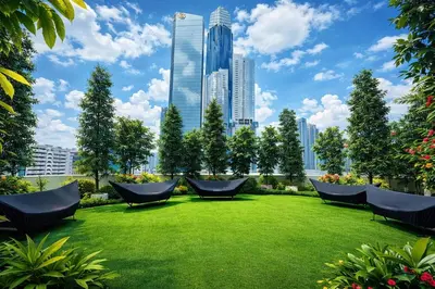 a park with chairs on a green lawn in a city at Bukit Bintang Service Apartment in Kuala Lumpur
