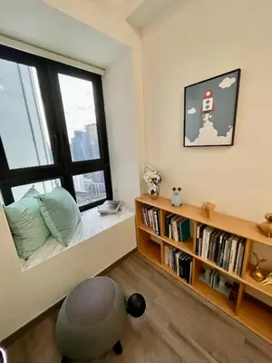 a bedroom with a window and a chair and a book shelf at Bukit Bintang Service Apartment in Kuala Lumpur
