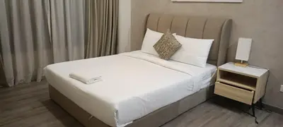 a bedroom with a large bed with white sheets and pillows at Family Suites at TRION KL in Kuala Lumpur