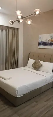 a bedroom with a large bed with white sheets at Family Suites at TRION KL in Kuala Lumpur