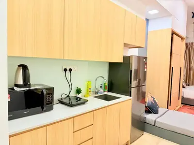 a kitchen with wooden cabinets and a microwave at The luxe by Kuala Lampur City in Kuala Lumpur