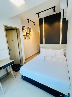 a bedroom with a large white bed and a desk at Sky property infinitum 2 in Kuala Lumpur