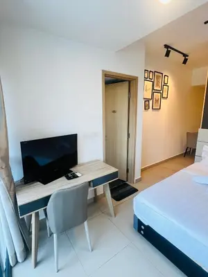 a bedroom with a desk with a television and a bed at Sky property infinitum 2 in Kuala Lumpur