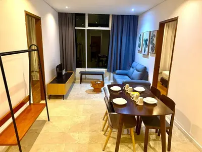 a living room with a table and a blue couch at Sky Suites Klcc By Bukit Bintang in Kuala Lumpur