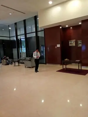 a person standing in a large lobby with a person standing at BTS Service suite at time square in Kuala Lumpur