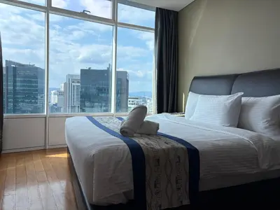 a bed with a stuffed animal sitting on it in front of a window at Vortex Suites klcc By MY FRAGRANCE in Kuala Lumpur