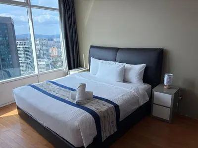 a bedroom with a large bed with a large window at Vortex Suites klcc By MY FRAGRANCE in Kuala Lumpur