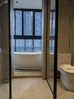 a bathroom with a tub and a window and a toilet at Alion Sutis KLCC At Scarlets in Kuala Lumpur