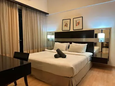 a bedroom with a large bed and a desk at Abadi Inn in Kuala Lumpur
