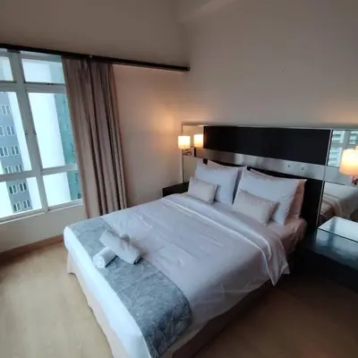 a bedroom with a large white bed with a large window at Abadi Inn in Kuala Lumpur
