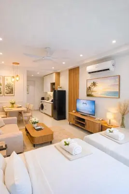 a living room with two beds and a television at Rooftop Pool At Majestic Residence in Kuala Lumpur