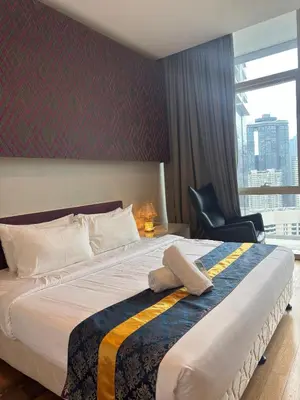 a hotel room with a large bed and a chair at Oras Suites At platinum KLCC in Kuala Lumpur