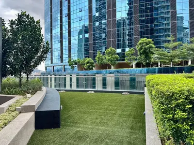 a lawn in front of a building with tall buildings at Dreamy KLCC Luxury Haven in Kuala Lumpur