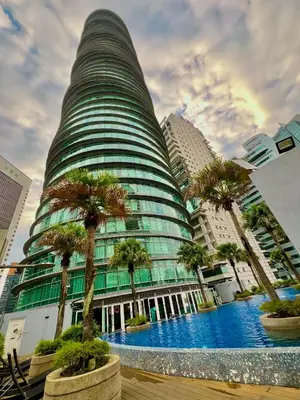 a tall building with palm trees in front of it at Vortex in Kuala Lumpur