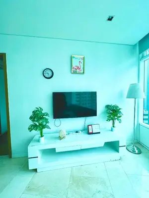 a living room with a white table and a tv at Vortex in Kuala Lumpur