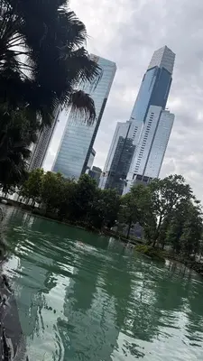 a pool of green water in front of tall buildings at Agile Residence Sky View Suites in Kuala Lumpur