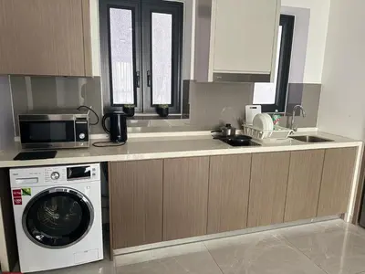 a kitchen with a washing machine and a microwave at Agile Residence Sky View Suites in Kuala Lumpur