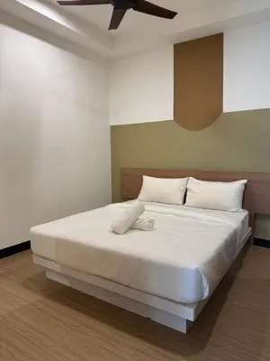 a bedroom with a white bed with a ceiling fan at Bukit Bintang Casa By Eryan Guest House in Kuala Lumpur