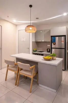 a kitchen with a large white counter and chairs at Trion Kuala Lumpur in Kuala Lumpur