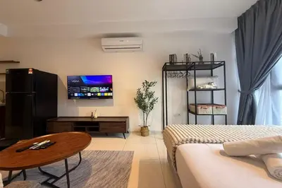 a living room with a bed and a tv at Majestic Residence KLCC by Luxe in Gua Sai