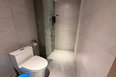 a small bathroom with a toilet and a shower at Majestic Residence KLCC by Luxe in Gua Sai