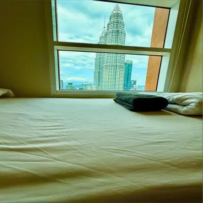 a bed in a room with a view of a city at Sky suites klcc by Ryan in Kuala Lumpur