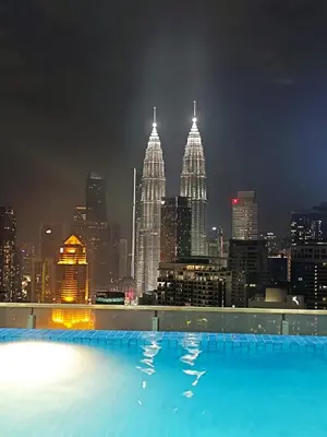 a rooftop swimming pool with a city skyline at night at The Wisma Infinitum KLCC By Kuala Lumpur City in Kuala Lumpur