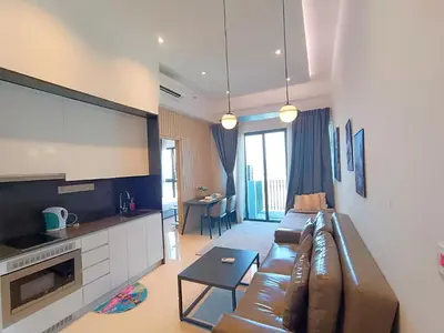 a living room with a brown couch and a kitchen at The Wisma Infinitum KLCC By Kuala Lumpur City in Kuala Lumpur