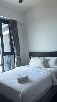 a bedroom with a white bed with a window at KL Sky Suite By Opus Residence in Kuala Lumpur