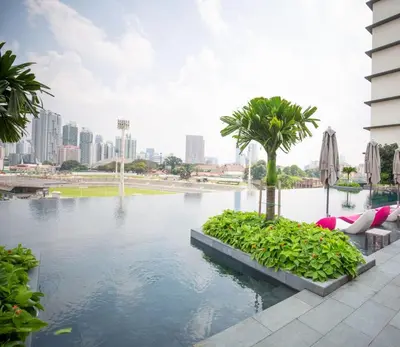 a swimming pool with a city skyline in the background at KL Sky Suite By Opus Residence in Kuala Lumpur