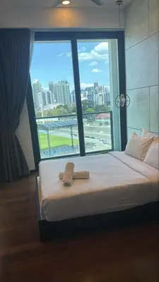 a bed with a towel on it in front of a window at KL Sky Suite By Opus Residence in Kuala Lumpur