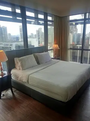 a large bed in a hotel room with windows at Healthy suite At Times Square KL in Kuala Lumpur