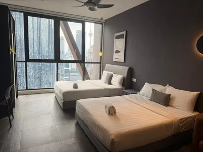 a hotel room with two beds and a large window at Metahome at Scarletz suites KLCC in Kuala Lumpur