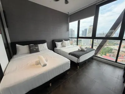 two beds in a room with large windows at Metahome at Scarletz suites KLCC in Kuala Lumpur