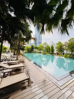 a swimming pool with benches and a city in the background at Agile Bukit Bintang TRX By Glanza Suites in Kuala Lumpur