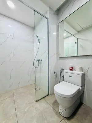 a bathroom with a toilet and a glass shower at Agile Bukit Bintang TRX By Glanza Suites in Kuala Lumpur
