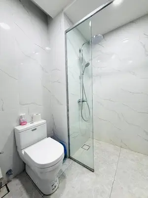 a bathroom with a toilet and a glass shower at Agile Bukit Bintang TRX By Glanza Suites in Kuala Lumpur