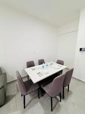 a dining room table with chairs and a white table and chairsktop at Agile Bukit Bintang TRX By Glanza Suites in Kuala Lumpur